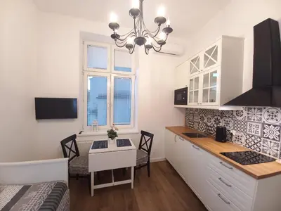a kitchen and dining room with a table and chairs at Krakowska Old Town Apartments - 16b in Kraków