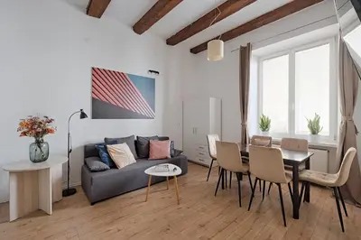 a living room with a couch and a table and chairs at Urban Nest Apartments Szewska 21 in Kraków
