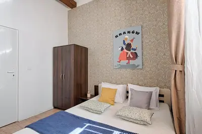 a bedroom with a bed and a painting on the wall at Urban Nest Apartments Szewska 21 in Kraków