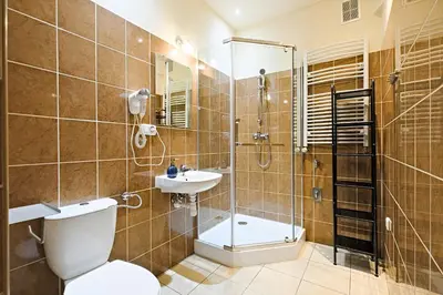 a bathroom with a shower and a toilet and a sink at Urban Nest Apartments Szewska 21 in Kraków
