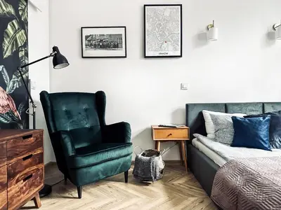 a bedroom with a bed and a green chair at Monkeyland - unique apartment in Old Podgorze in Kraków