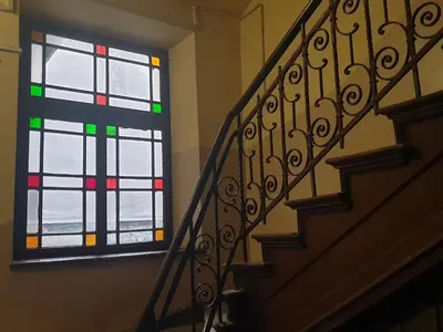 a staircase with a stained glass window in a building at Monkeyland - unique apartment in Old Podgorze in Kraków