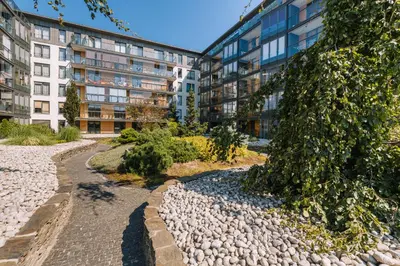a garden in front of an apartment building at ApartmentPrestige - Boulevard in Kraków