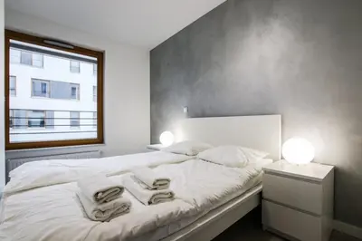 a bedroom with a white bed with towels on it at ApartmentPrestige - Boulevard in Kraków