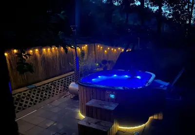 a hot tub in a backyard at night with lights at Pod Magnolią in Targanice