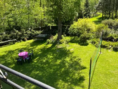 a patio with a table and chairs in the grass at Pod Magnolią in Targanice