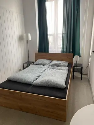 a bed with a wooden frame in a bedroom at Amazing view rooms in Old Town in Kraków