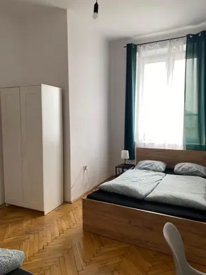 a bedroom with a large bed and a window at Amazing view rooms in Old Town in Kraków