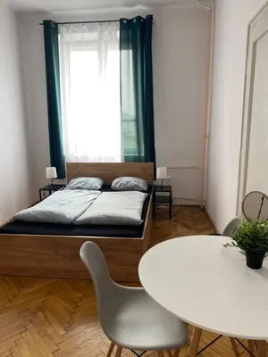 a bedroom with a bed and a table and a table and chairs at Amazing view rooms in Old Town in Kraków