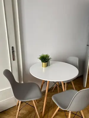 a white table with two chairs and a potted plant at Amazing view rooms in Old Town in Kraków