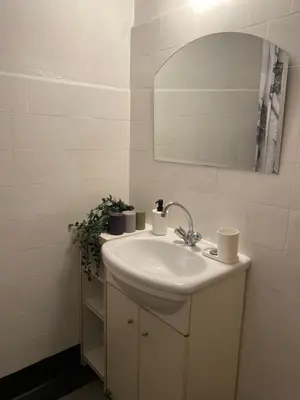a white bathroom with a sink and a mirror at Amazing view rooms in Old Town in Kraków