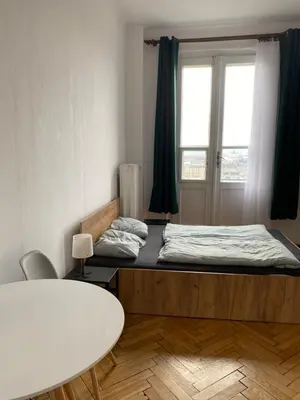 a room with a bed and a table and a window at Amazing view rooms in Old Town in Kraków