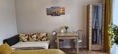 a living room with a table and chairs and a couch at Cozy modern Apartment SUNRISE studio 35m2 balcony 3 persons in Kraków