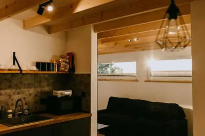 a kitchen with a sink and a couch in a room at Domki pod Kamionna in Laskowa