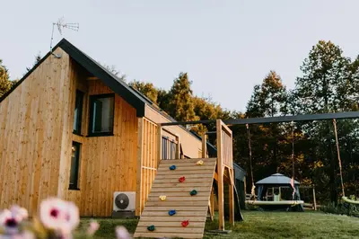 a wooden house with a slide and a playground at Domki pod Kamionna in Laskowa