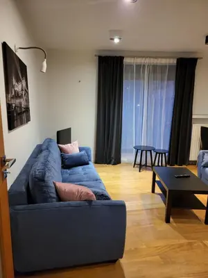 a living room with a blue couch and a table at Amber Hostel Szlak in Kraków