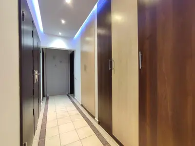a hallway with wooden doors and a tile floor at Amber Hostel Szlak in Kraków