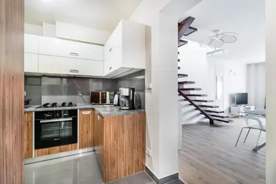 a kitchen and living room with a table and chairs at Radziwillowska Old Town Deluxe Apartment WAWELOFTS in Kraków