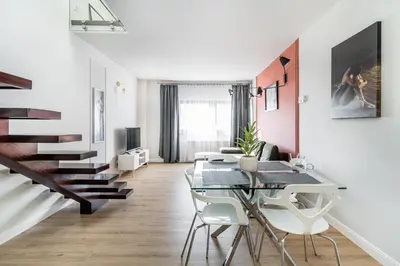 a white living room with a table and a couch at Radziwillowska Old Town Deluxe Apartment WAWELOFTS in Kraków