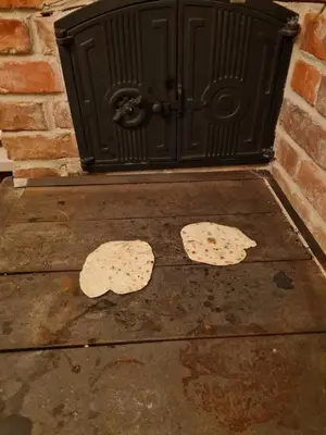 two slices of pizza on a sidewalk in front of a fireplace at Morowo chałupa in Czchów