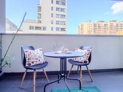 a table and two chairs on a balcony at Miły czas in Kraków