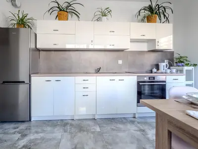 a kitchen with white cabinets and stainless steel appliances at Miły czas in Kraków