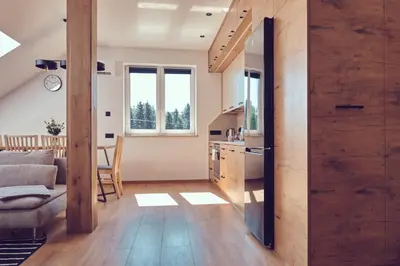 a kitchen and living room with a large wooden wall at WieliczkaHome 1st floor + garden + parking in Wieliczka