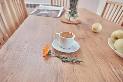 a cup of coffee sitting on a wooden table at WieliczkaHome 1st floor + garden + parking in Wieliczka