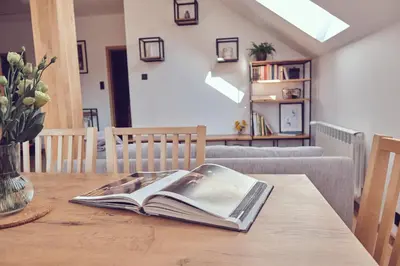 an open book on a wooden table in a living room at WieliczkaHome 1st floor + garden + parking in Wieliczka
