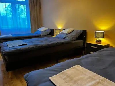 a room with two beds and a couch and a window at Komfortowy Apartament w centrum in Jaworzno