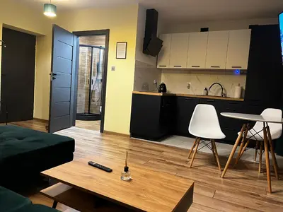 a living room with a couch and a table and a kitchen at Komfortowy Apartament w centrum in Jaworzno