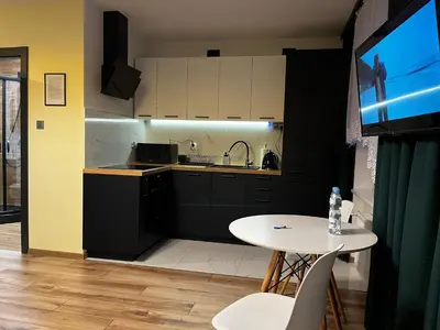 a kitchen with a table and a sink and a tv at Komfortowy Apartament w centrum in Jaworzno