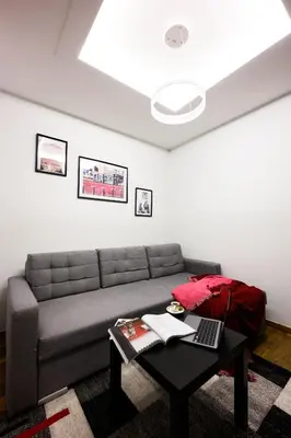 a living room with a couch and a table with a laptop at Native Apartments Masarska 8/5 in Kraków
