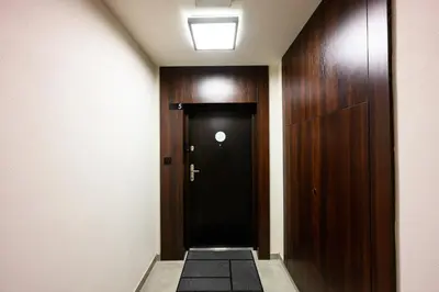 a hallway with a black door in a building at Native Apartments Masarska 8/5 in Kraków
