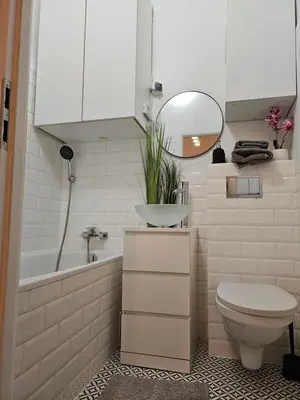 a bathroom with a toilet and a sink and a mirror at Apartamenty Lenart in Kraków