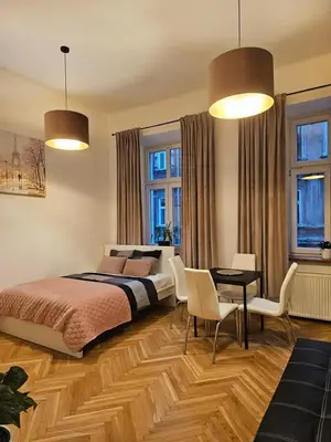a bedroom with a bed and a table and chairs at Apartamenty Lenart in Kraków