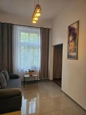 a living room with a couch and a window at Apartamenty Lenart in Kraków