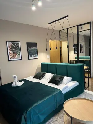 a bedroom with a blue bed and a table at Tauron Arena Apartment with Garage - Kraków Lema in Kraków