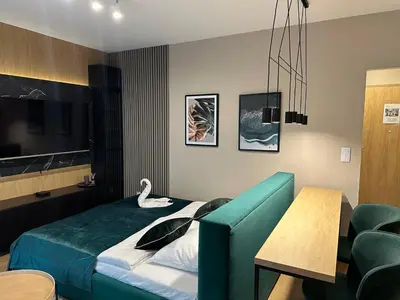 a hotel room with a bed and a swan on it at Tauron Arena Apartment with Garage - Kraków Lema in Kraków
