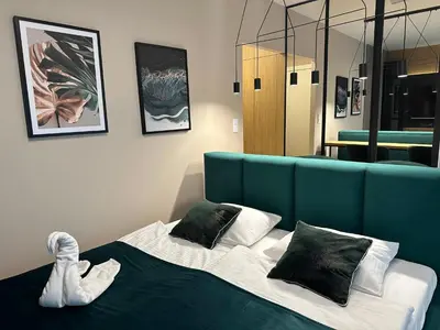 a bedroom with a bed with a blue head board at Tauron Arena Apartment with Garage - Kraków Lema in Kraków