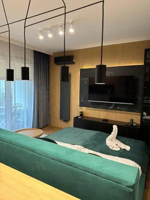 a bedroom with a green bed and a tv at Tauron Arena Apartment with Garage - Kraków Lema in Kraków