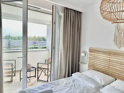 a bedroom with a bed and a balcony at Złota Nowa Huta in Kraków