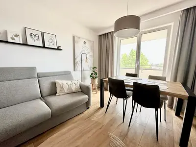 a living room with a couch and a table and chairs at Złota Nowa Huta in Kraków