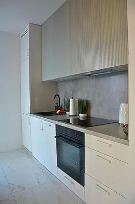 a kitchen with white cabinets and a black oven at Apartament na wynajem 32 m2 in Bochnia
