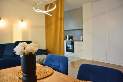a living room with a table and blue chairs at Apartament na wynajem 32 m2 in Bochnia