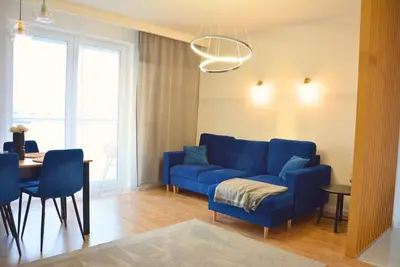 a living room with a blue couch and a table at Apartament na wynajem 32 m2 in Bochnia