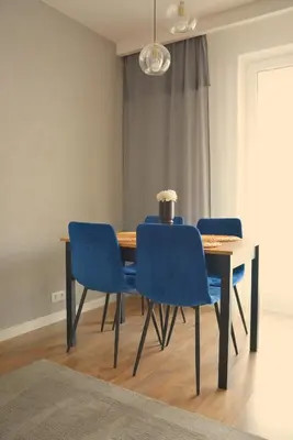 a dining room table with four blue chairs and a table at Apartament na wynajem 32 m2 in Bochnia