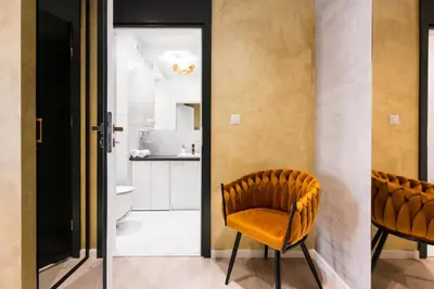 a room with a yellow chair and a bathroom at Salomea apartments Kraków, Stary Kazimierz, Tauron arena in Kraków