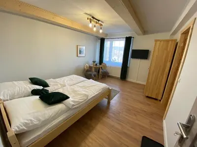 a bedroom with a bed with white sheets and green pillows at Willa Pod Wyciągiem in Spytkowice
