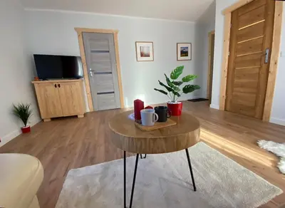 a living room with a coffee table and a tv at Willa Pod Wyciągiem in Spytkowice